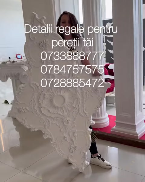 Persoană transportă rozeta uriașă prin showroom cu coloane