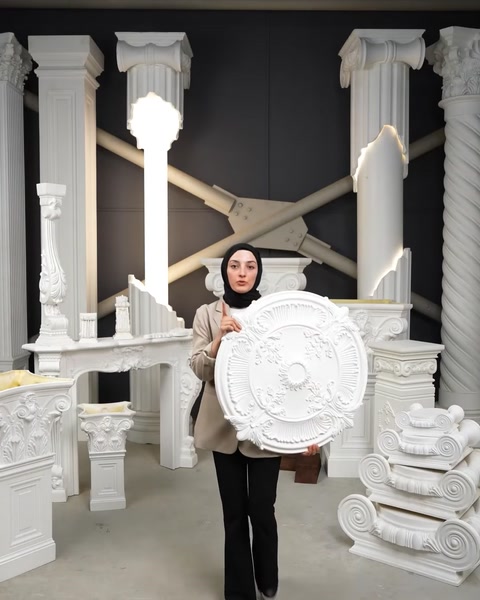 Femeie prezintă o rozetă decorativă rotundă din poliuretan în showroom.