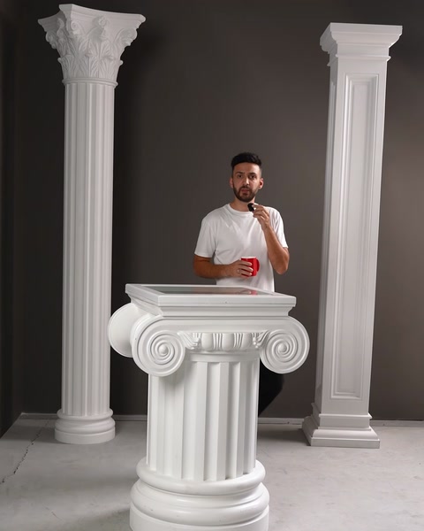 Bărbat lângă soclu alb cu capitel ionic pentru coloană.