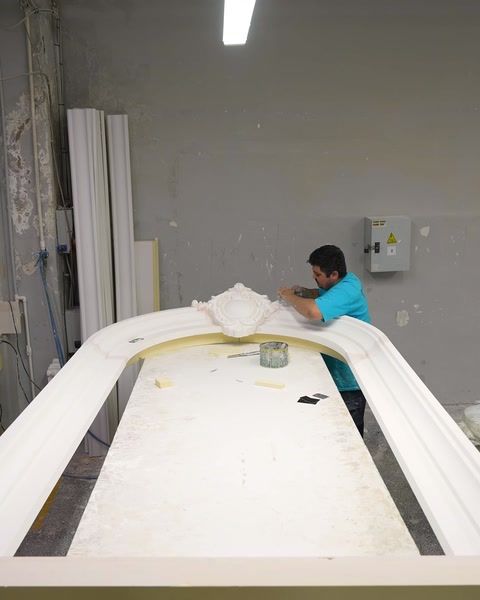 Lucrătorul finisează un cadru arcuit într-un atelier specializat