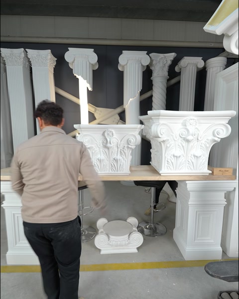 Coloane corintice complete aliniate lângă perete în hala de producție.