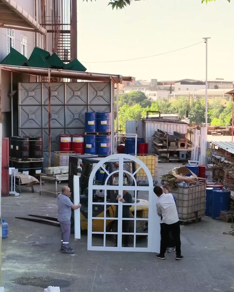 Doi muncitori transportă panoul arcuit al ferestrei false