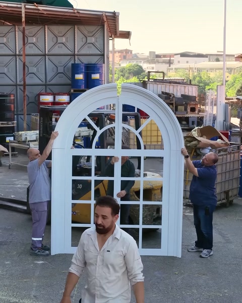 Bărbat ajustează fereastra falsă montată vertical în curte