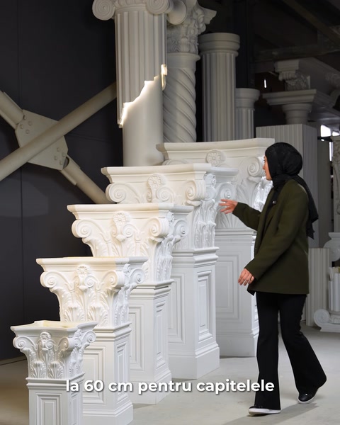 Femeie trece prin hala de producție plină cu coloane poliuretan.