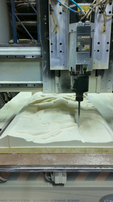 Utilaj CNC care prelucrează un relief floral într-o placă