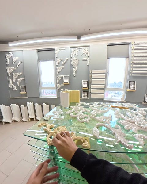 Masă de sticlă cu mostre de ornamente în showroom
