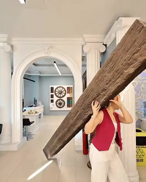 Grindă cu textură de lemn vechi cărată printr-o arcadă decorativă.