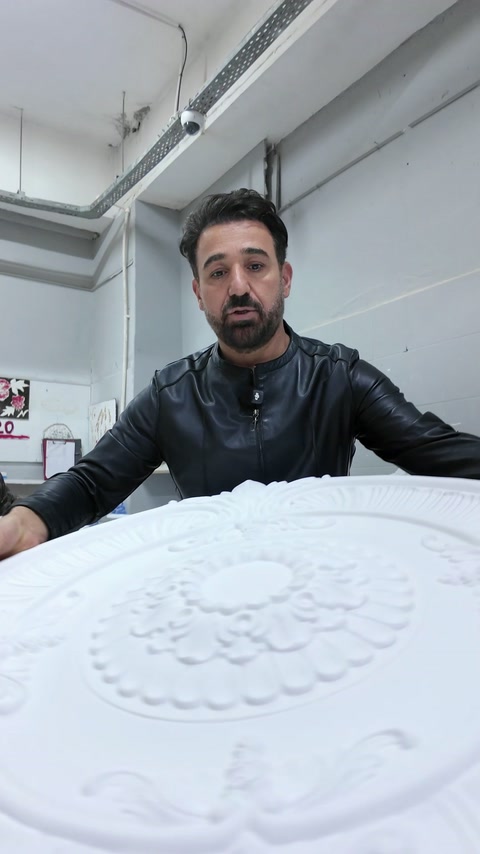 Detaliu frontal al rozetei cu motive florale în relief.