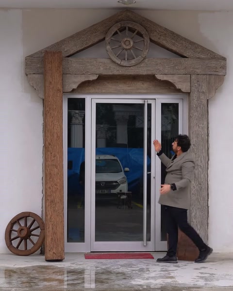 Bărbat ridică piesa roată decorativă de pe sol lângă intrare
