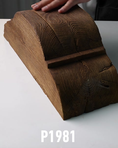 Piesa brună curbată evidențiază textura inspirată de lemn.