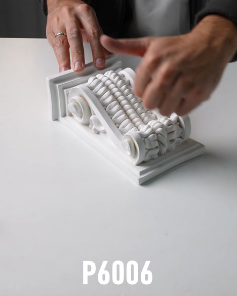 Un ornament alb este completat cu elemente decorative reliefate.