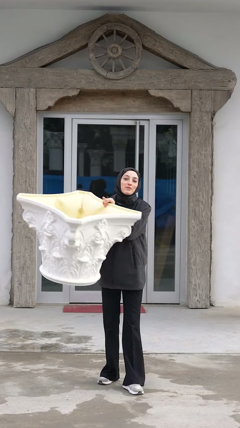 Detaliu frontal al capitelului decorativ ținut la nivelul pieptului