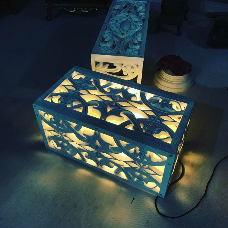 Casete Luminate din Panouri Decorative din Poliuretan Panourile decorative din poliuretan cu decupaje traforate sunt elemente arhitecturale versatile utilizate pentru decorarea pereților și crearea corpurilor de iluminat ambientale în locuință. În sufrageria noastră, am ales să transformăm panourile de poliuretan din colecția P8105 și P8107 în două casete decorative luminate la nivelul pardoselii, oferind spațiului o atmosferă caldă și primitoare în serile de relaxare. Lumina caldă cu o temperatură de culoare de aproximativ 2700K difuzată prin motivele clasice traforate creează un joc subtil de umbre pe parchet, aducând un confort vizual deosebit și un punct de atracție vizuală în colțul de lectură.
Această amenajare din zona de zi a devenit repede locul preferat al familiei noastre după o zi lungă de muncă. În loc să folosim o lumină principală de plafon adesea prea puternică, aprinderea acestor casete realizate din panouri decorative din poliuretan creează un ambient intim și relaxant. Textura mată a materialului poliuretanic contrastează plăcut cu strălucirea luminii interioare, oferind impresia unor piese de mobilier de artă realizate la comandă. Este o soluție practică și estetică ce redefinește complet atmosfera din living în timpul serilor petrecute alături de cei dragi.
Materialul poliuretanic de înaltă densitate, cu o densitate tehnică de aproximativ 150-220 kg/m³ (țintă ~160 kg/m³), garantează o rezistență excelentă la impact și stabilitate dimensională în timp. Panourile din poliuretan au o rată redusă de absorbție a apei de sub 1% și rezistă la fluctuații de temperatură între -100 °C / +80 °C, fiind ideale pentru integrarea surselor de iluminat LED fără risc de deformare. Datorită greutății reduse și ușurinței de tăiere, panourile decorative pot fi îmbinate la unghiuri precise de 45 de grade pentru a construi structuri tridimensionale durabile și ușor de întreținut în orice cameră.
Integrat în decorul din casa noastră, poliuretanul demonstrează că poate depăși funcția clasică de profil sau baghetă de perete. Transformarea panourilor decorative din poliuretan în corpuri de iluminat la nivelul podelei oferă o alternativă modernă și călduroasă la corpurile de iluminat convenționale. Suprafața panourilor poate fi vopsită cu vopsele pe bază de apă în nuanțele dorite, permițând adaptarea perfectă la paleta cromatică a camerei și crearea unui cămin cu adevărat personalizat.