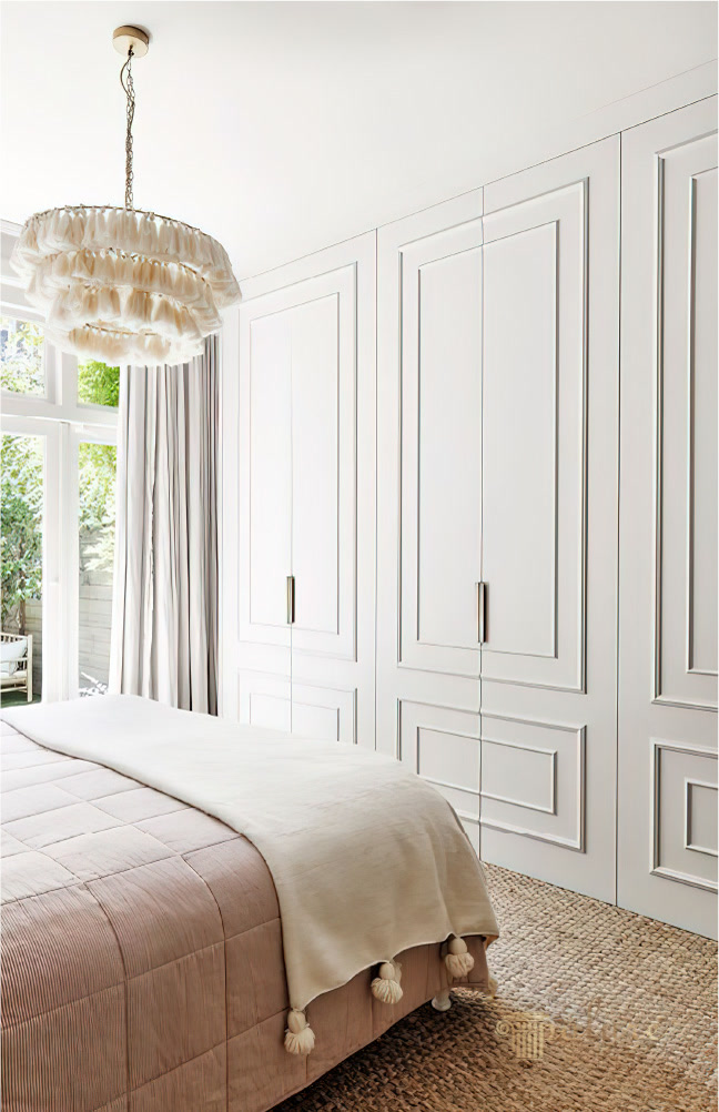 Dulap Încorporat cu Profile din Poliuretan pentru Dormitor Profilele decorative din poliuretan P85002 și P85008 reprezintă soluția ideală pentru personalizarea ușilor de dulap și transformarea mobilierului simplu într-o piesă de accent elegantă. În fiecare dimineață, lumina naturală pătrunde generos prin ferestrele înalte ale dormitorului, punând în valoare textura rafinată a suprafețelor finisate cu aceste baghete decorative. Atmosfera din încăpere devine instantaneu mai primitoare și mai ordonată, oferind un sentiment profund de liniște, confort și armonie zilnică pentru întreaga familie.

Utilizarea zilnică a acestui spațiu de dormit demonstrează modul în care detaliile arhitecturale subtile pot schimba complet percepția asupra unei camere. Ușile dulapului integrat, decorate cu baghete din poliuretan de înaltă densitate de aproximativ 150-220 kg/m³ (țintă ~160 kg/m³), adaugă profunzime vizuală și structură pereților. Nuanțele calde de crem și bej neutru se îmbină armonios cu textura covorului din iută naturală și cu lenjeria matlasată, creând un sanctuar privat de relaxare după o zi lungă de muncă.

Din punct de vedere tehnic și practic, poliuretanul utilizat pentru baghetele P85002 și P85008 oferă o rezistență excelentă la umezeală, având o rată de absorbție a apei sub 1%, și rezistă la variații de temperatură cuprinse între -100 °C / +80 °C. Înainte de vopsire, suprafața profilelor a fost pregătită cu hârtie abrazivă de granulație 240 și finisată cu o vopsea lavabilă mată, obținându-se o continuitate cromatică impecabilă între cadrul mobilierului și detaliile reliefate.

Acest dormitor modern reușește să combine funcționalitatea unui dressing generos cu un design cald și primitor pentru viața de zi cu zi. Cadrul decorativ oferit de profilele poliuretanice transformă fiecare colț al camerei într-un spațiu estetic plăcut, durabil și extrem de ușor de întreținut prin curățare periodică simplă.