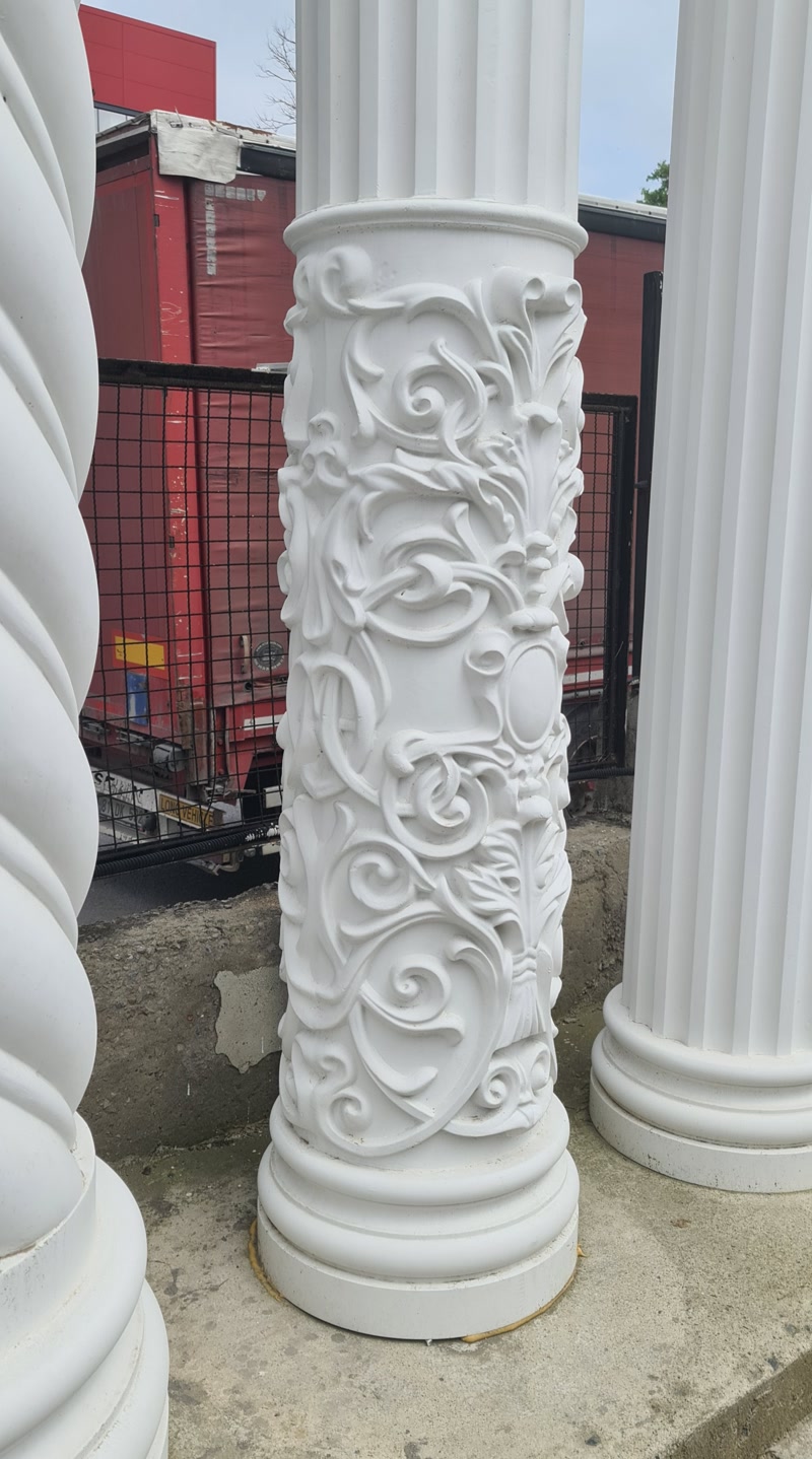 Coloane decorative din poliuretan alb cu sculpturi detaliate și striații clasice pregătite pentru montaj.