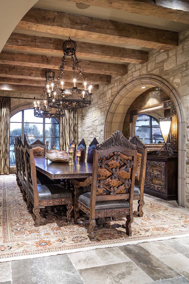 Grinzi din Poliuretan pentru Tavan Rustic în Living Grinzile decorative din poliuretan reprezintă o soluție tehnică și estetică excelentă pentru a transforma un spațiu generos de dining într-un loc cald și primitor. În această sală de mese cu arhitectură rustică, structura tavanului a fost conturată cu ajutorul grinzilor decorative, oferind senzația imediată a unei cabane sau a unui conac istoric. Cu o densitate ridicată de 150-220 kg/m³ (țintă ~160 kg/m³), aceste grinzi imită fidel textura, nodurile și crăpăturile naturale ale lemnului de stejar, dar fără greutatea mare a masei lemnoase tradiționale. Seara, când candelabrele din fier forjat sunt aprinse, umbrele calde proiectate pe tavan creează o atmosferă deosebit de intimă pentru cinele în familie.
Utilizarea elementelor poliuretanice precum modelele P1981B, P1981C, P1981D, P1981E, P1981F, P1981G și P1981K permite realizarea unui plafon casetat sau cu căpriori paraleli într-un timp foarte scurt. Deoarece materialul are o rezistență termică excelentă între -100 °C / +80 °C, grinzile își păstrează forma perfectă în timp, fără a se crăpa sau distorsiona din cauza fluctuațiilor de temperatură din locuință. Masa din lemn masiv și scaunele sculptate din încăpere se potrivesc de minune cu această structură superioară, creând o armonie vizuală între pardoseala din piatră naturală și tavanul cald.
Un alt avantaj major în amenajarea unei zone de dining cu grinzi din poliuretan este rezistența lor la umiditate, având o rată de absorbție a apei de sub 1%. Spre deosebire de grinzile din lemn natural, care necesită tratamente periodice împotriva cariilor și a mucegaiului, profilul din poliuretan nu atrage dăunători și se curăță foarte ușor cu o lavetă umedă. Acest lucru face ca întreținerea unui tavan rustic spectaculos să fie extrem de simplă pentru o familie ocupată, păstrând aspectul impecabil an de an.
Montajul grinzilor pe tavan se realizează rapid prin lipire cu adezivi structurali speciali, eliminând necesitatea unor ancoraje metalice grele în plăcile de beton. Într-un spațiu în care piatra naturală și finisajele clasice predomină, tavanul decorat cu grinzi poliuretanice aduce doza necesară de căldură vizuală, făcând ca fiecare masă alături de cei dragi să devină o experiență memorabilă într-un cadru plin de caracter.
