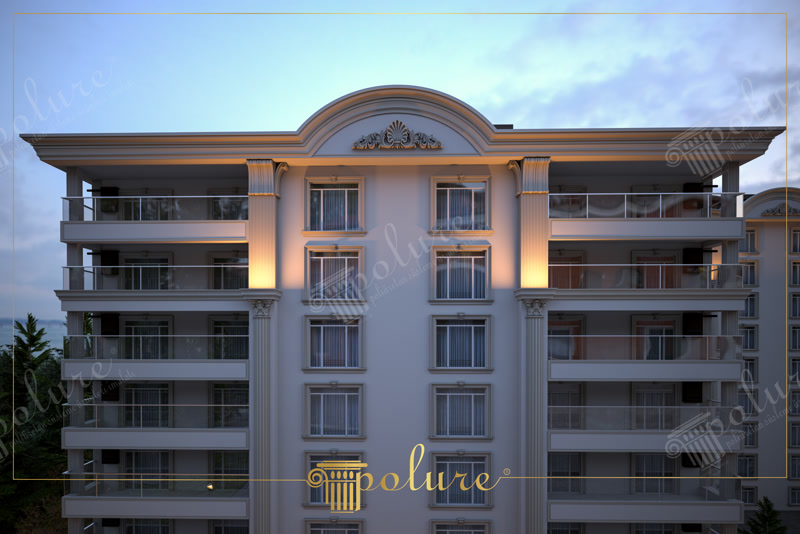 Fatada Cladire cu Elemente Decorative din Poliuretan Stil Clasic Decorarea exterioara cu profiluri din poliuretan de inalta densitate, de 150-220 kg/m³ (țintă ~160 kg/m³), reprezinta o solutie durabila si eleganta pentru transformarea vizuala a cladirilor cu mai multe niveluri. Aceasta fatada clasica redefineste confortul si prestigiul unei locuinte de familie, oferind o arhitectura primitoare unde fiecare detaliu este gandit pentru a spori valoarea estetica a caminului. Structura simetrica pe 6 etaje imbina armonia liniilor verticale cu balcoanele moderne, creand o atmosfera calda si sofisticata inca de la prima privire aruncata spre cladire. Seara, jocul de lumini calde pe suprafata fatadei pune in valoare decoratiunile arhitecturale si ofera un sentiment primitor tuturor locatarilor care se intorc acasa.
Locuirea intr-un astfel de spatiu de inspiratie neoclasica ofera o experienta zilnica plina de rafinament si confort vizual. Ferestrele mari, incadrate de ancadramente fine din poliuretan, permit luminii naturale sa patrunda din abundenta in living si in dormitoare, creand un mediu luminos si spatios pentru intreaga familie. Pilastrii verticali striati care strabat etajele cladirii ofera o senzatie de protectie si stabilitate, transformand intregul ansamblu rezidential intr-o oaza de liniste si stil. Balcoanele prevazute cu balustrade din sticla securizata completeaza eleganta profilurilor decorative clasice, oferind familiilor un loc perfect pentru a admira apusul sau pentru a savura cafeaua de dimineata.
Proprietatile tehnice ale elementelor din poliuretan garanteaza o rezistenta impecabila in timp, fara a necesita intretinere complicata sau costisitoare din partea proprietarilor. Materialul dens prezinta un coeficient de absorbtie a apei sub 1% si o rezistenta termica excelenta la temperaturi extreme cuprinse intre -100 °C / +80 °C, protejand exteriorul cladirii impotriva umezelii, inghetului si razelor ultraviolete. Spre deosebire de ipsosul traditional sau betonul decorativ greu, profilurile usoare din poliuretan nu incarca structura de rezistenta a cladirii si pot fi montate rapid pe sistemele termoizolante existente. Vopseaua acrilica de exterior aplicata peste elemente mentine nuanta curata de gri si bej cald, protejand decorul impotriva factorilor de mediu.
Investitia intr-o fatada decorata cu elemente profilate din poliuretan transforma orice imobil intr-o casa cu personalitate distincta si un farmec atemporal. Combinatia dintre frontonul arcuit ornamentat, stucaturile sofisticate si sistemele moderne de iluminat exterior creeaza o identitate vizuala memorabila, perfecta pentru un stil de viata primitor. Fiecare proprietar se poate bucura de mandria de a locui intr-o cladire cu un design distins, unde traditia arhitecturala clasica se intalneste armonios cu standardele moderne de confort si durabilitate.