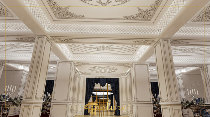 Decoratiuni Tavan si Pereti din Poliuretan pentru Salon Poliuretanul de înaltă densitate este un material decorativ modern cu o densitate structurală cuprinsă între 180 și 150-220 kg/m³ (țintă ~160 kg/m³), utilizat pentru crearea detaliilor arhitecturale clasice în saloane și spații de primire primitoare. Când am început amenajarea salonului nostru principal, ne-am dorit un spațiu luminos, cald și prietenos, unde întreaga familie să se poată aduna la sărbători și mese festive. Alegerea elementelor decorative arhitecturale din poliuretan a transformat complet percepția încăperii noastre. Tavanele înalte au fost structurate cu casete elegante și cornișe P81159A, creând o atmosferă primitoare în care lumina caldă a LED-urilor ascunse se difuzează armonios pe suprafețele crem.
În centrul acestui spațiu de zi, stâlpii de susținere au fost transformați în pilatri arhitecturali impresionanți folosind modelele P5024A și P5024B, adăugând un sentiment de ordine și echilibru întregii încăperi. Pentru a îmbrăca pereții și a le oferi o textură bogată dar primitoare, am integrat panouri decorative P82210 completate de baghete și chenare fine P85002 și P85008. Colțurile elegante formate cu elementele P85002C și P85008C oferă continuitate vizuală, făcând ca salonul să pară mai spațios și mai organizat pentru momentele speciale petrecute alături de cei dragi.
Pe lângă aspectul estetic cald și primitor, proprietățile tehnice ale profilurilor decorative din poliuretan joacă un rol esențial în confortul zilnic al casei noastre. Materialul garantează o rezistență excelentă la fluctuații de temperatură între -100 °C / +80 °C și o rată de absorbție a apei de sub 1%, prevenind crăpăturile sau deformările în timp. Ornamentele sculptate P8055A, P8088B, P8088C, P8088D și P8088E aplicate pe tavan adaugă detalii fine, dar extrem de durabile la impactul mecanic moderat. Astfel, spațiul rămâne impecabil chiar și în timpul întâlnirilor numeroase de familie.
Procesul de instalare a fost extrem de simplu și curat pentru întreaga familie, fixarea profilurilor realizându-se rapid cu adezivi poliuretanici speciali, urmată de aplicarea unei vopsele lavabile fără solvenți. Tonalitățile calde de fildiș și crem alese pentru pereți și tavan creează o atmosferă primitoare, în timp ce draperiile din catifea albastră adaugă un accent de culoare confortabil. Prin combinarea acestor elemente poliuretanice de calitate, salonul nostru a devenit locul preferat de întâlnire al casei, îmbinând confortul zilnic cu un stil decorativ impecabil.