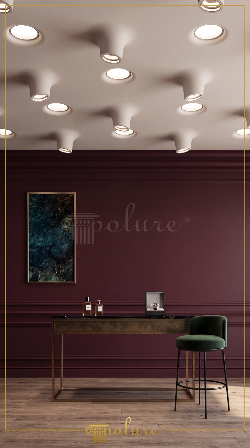 Tavan modern cu casete speciale din poliuretan pentru spoturi încastrate și perete bordou într-un spațiu elegant de locuit.